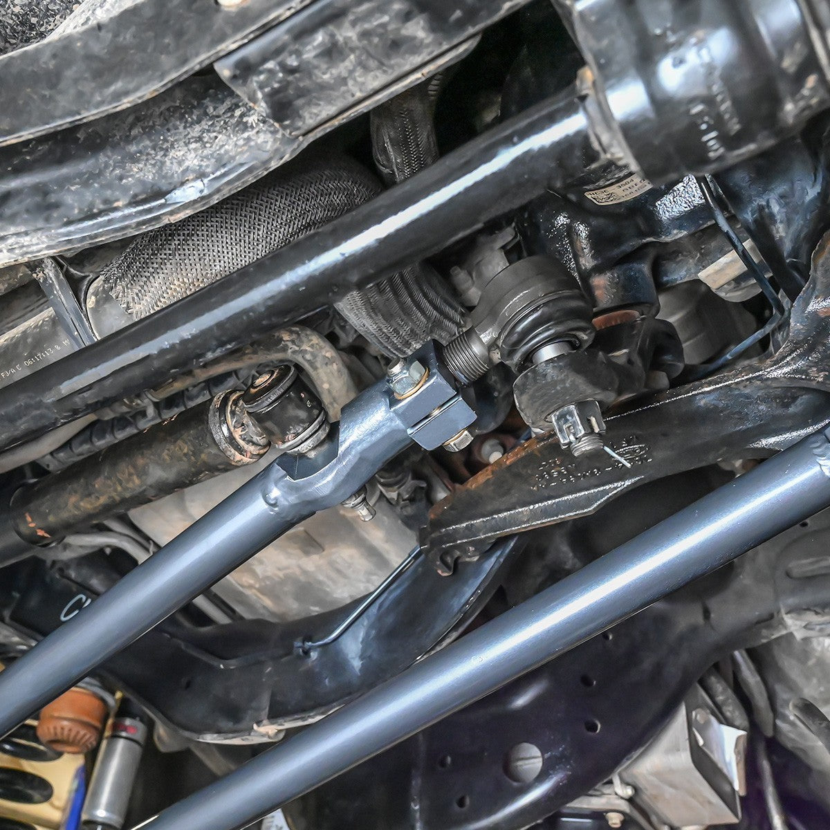Synergy Manufacturing heavy duty drag link installed on the front axle of a Ford Super Duty F-250